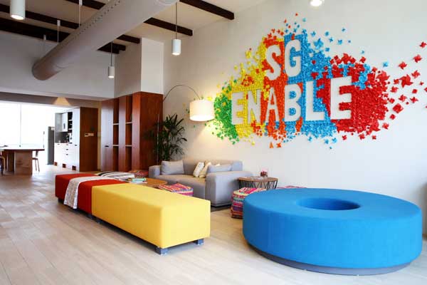 Interior of the SG Enable Office. A wall is decorated with vibrantly coloured paper decorations created by SG Enable staff.