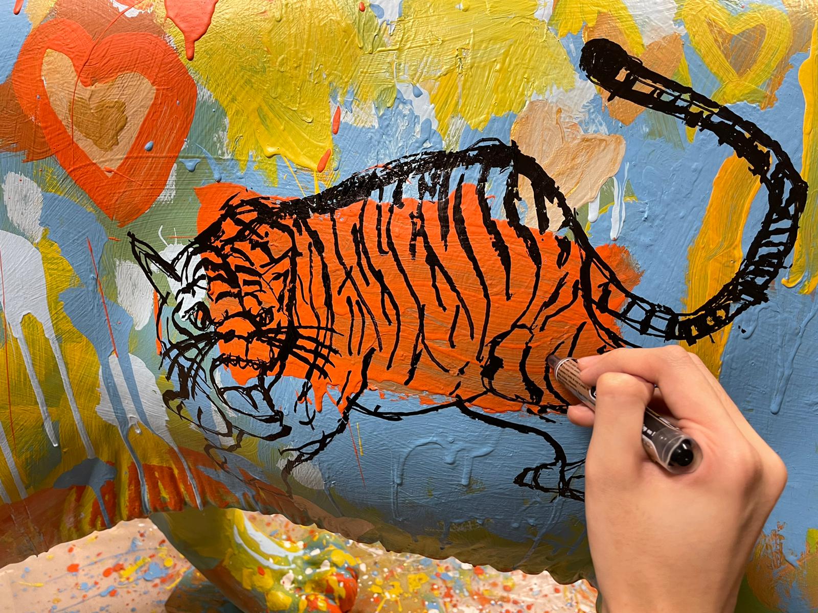 The Animal Project artist sketching a tiger on the sculpture