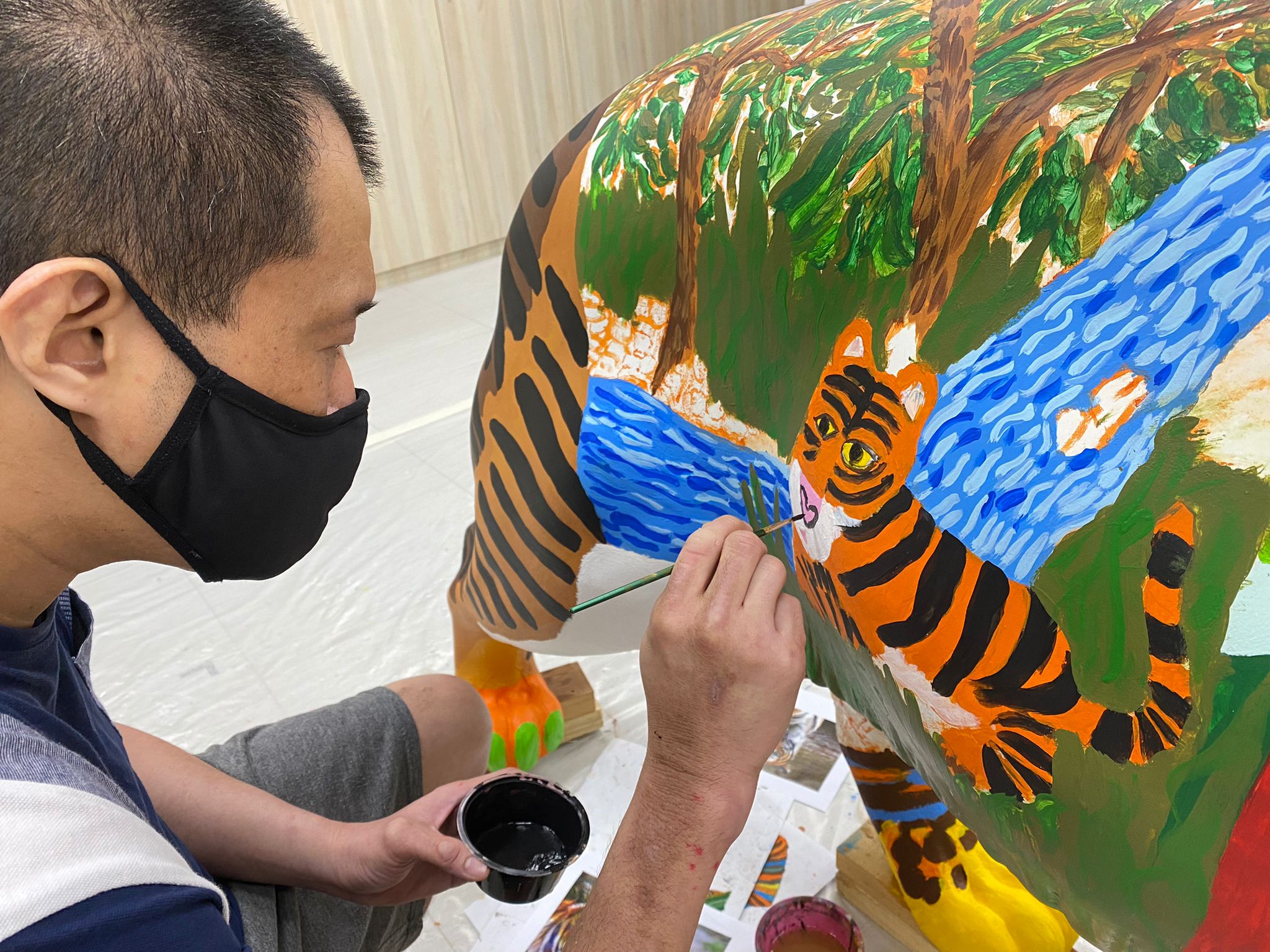 JOURNEY by TOUCH Community Services artist painting on the tiger sculpture 