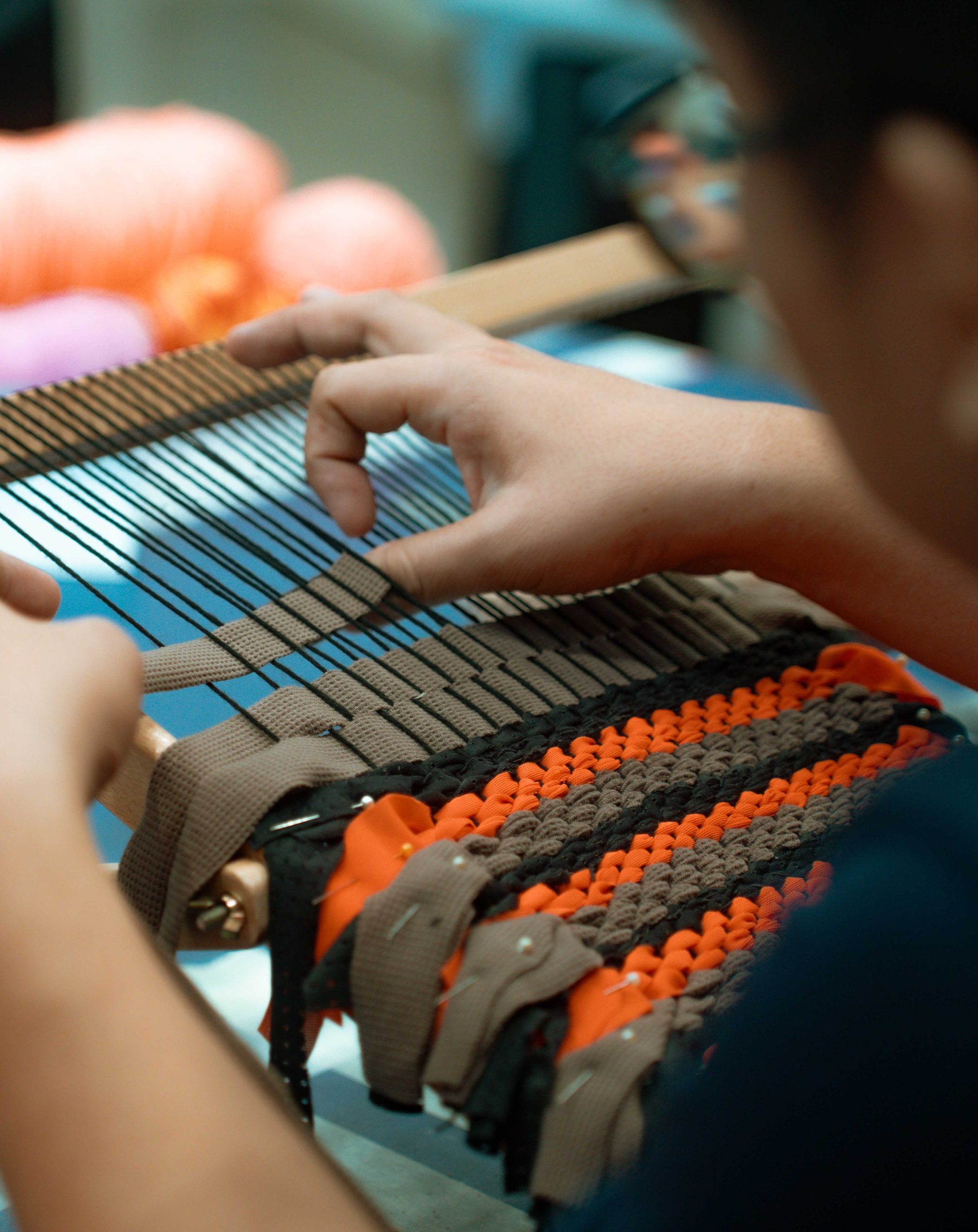 Clarence weaving fabric strips in hand loom